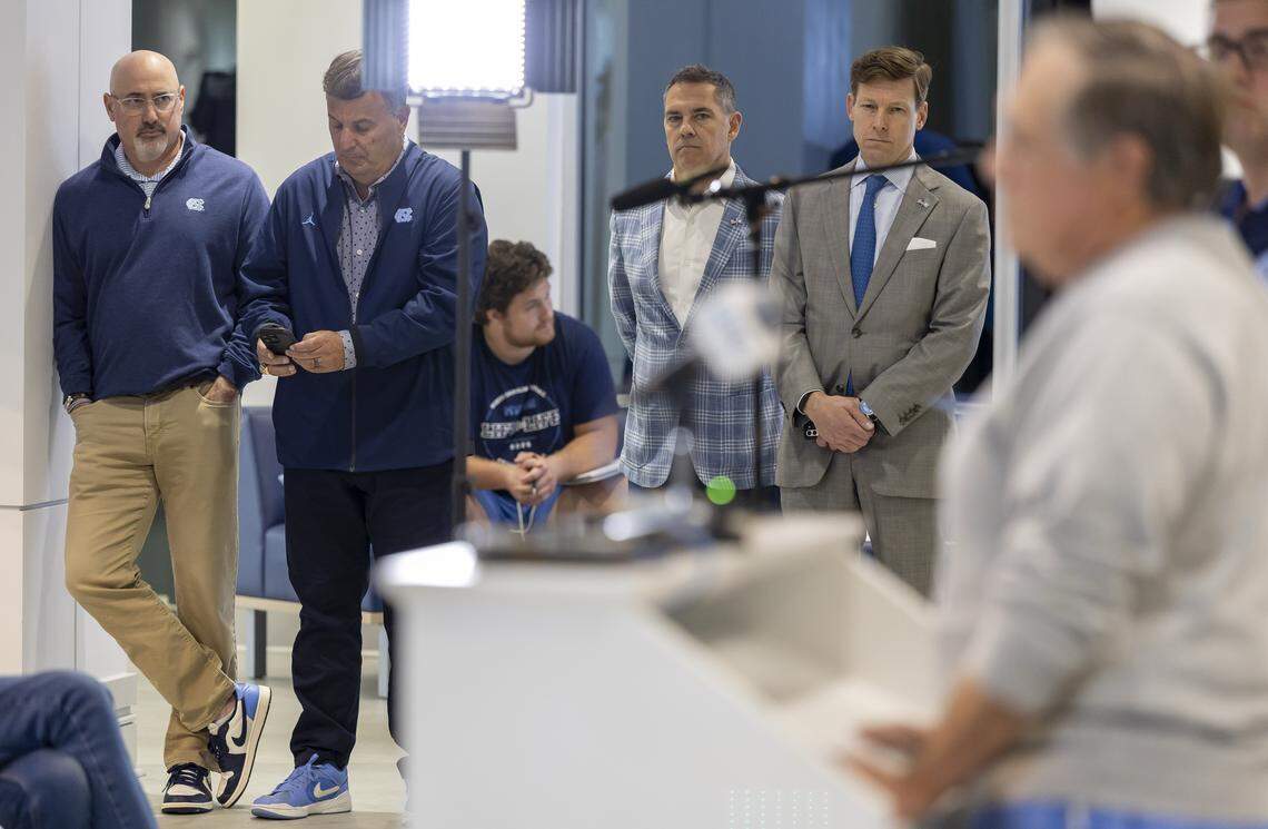 Executive Associate Athletic Director Steve Newmark,  football General Manager Michael Lombardi , Vice Chancellor for Communications Dean Stoyer and Chancellor Lee Roberts listen during Bill Belichick’s press conference on Monday October 13, 2025 at Kenan Stadium in Chapel Hill, N.C.