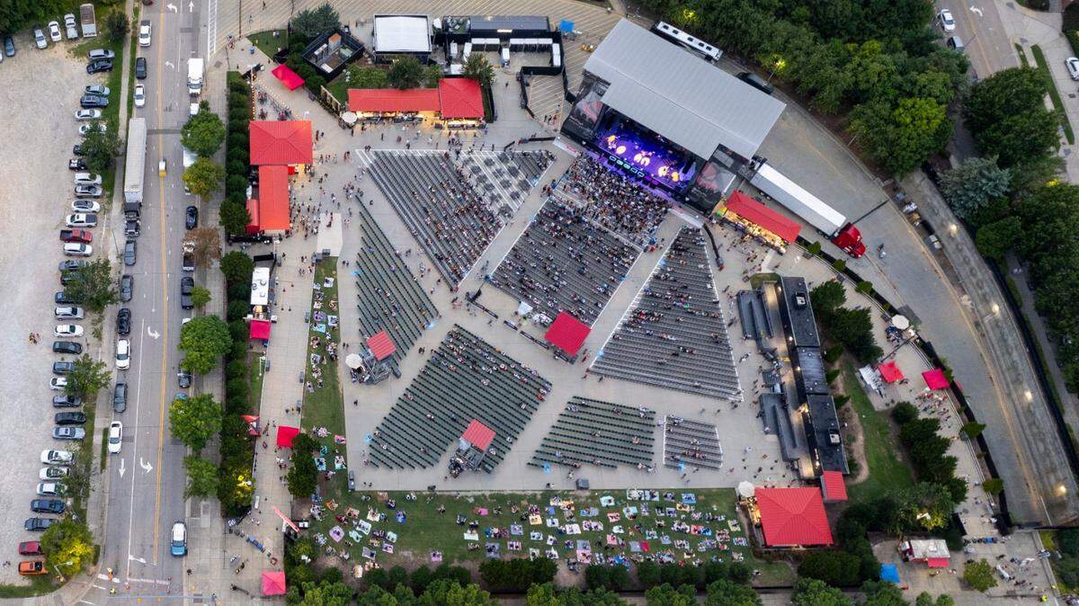 An aerial view of Red Hat Amphitheater, at right, with Lenoir Street, center, and South Street, left, in downtown Raleigh seen prior to a concert on Tuesday, Aug. 13, 2024. A proposed plan to relocate Red Hat Amphitheater would permanently close a block of South Street to traffic.