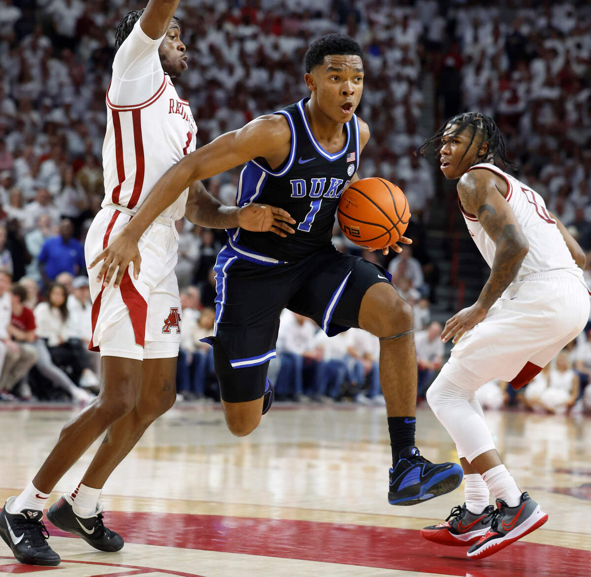 Duke’s Caleb Foster (1) gets past Arkansas’ Davonte Davis (4) during the first half of Duke’s game against Arkansas at Bud Walton Arena in Fayetteville, Ark., Weds. Nov. 29, 2023.
