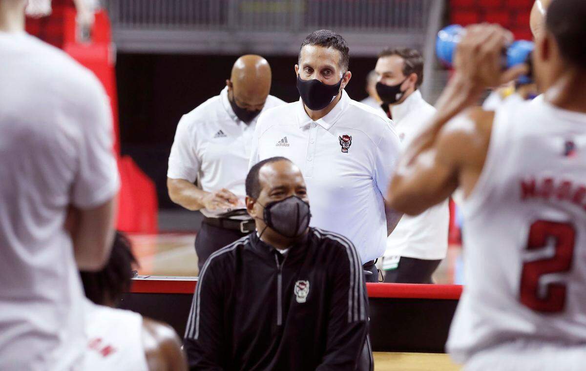 Chris Zupko, assistant director of N.C. State’s men’s basketball operations, center, listens as Kevin Keatts talks to the team during a timeout during the game against Pittsburgh at PNC Arena in Raleigh, N.C., Sunday, February 28, 2021.
