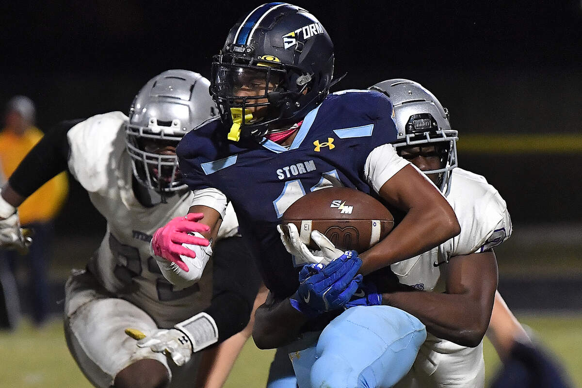 Willow Spring running back Amir Wallace (11) rushes for yardage against South Garner’s Sebastian Cruz (21) during the second half. The Willow Spring Storm and the South Garner Titans met in a football game in Fuquay-Varina. N.C. on October 18, 2024.
