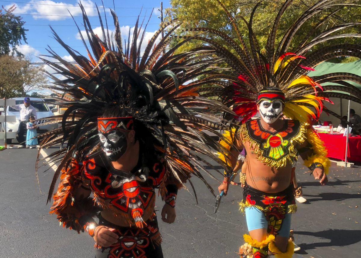 Members of Danza Azteca Henderson perform at a Day of the Day celebration outside El Pueblo’s offices in Raleigh, N.C., on Oct. 31, 2021