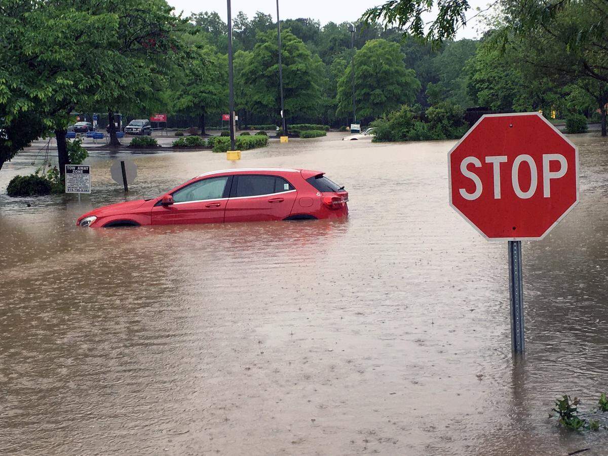 A car sits in flood waters in a parking lot at Six Forks and Wake Forest Roads in Raleigh on Tuesday, April 25, 2017. Heavy overnight rains flooded many low-lying areas of Raleigh.