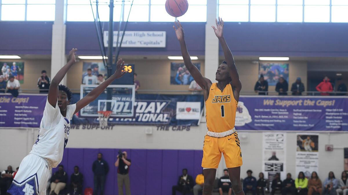 Terquavion Smith (1) of Farmville Central shoots for 3 points against Julien King, left, of Broughton. The Farmville Central Jaguars played the Broughton Capitals in a boys basketball game that was part of the John Wall Holiday Invitational on December 26, 2019.