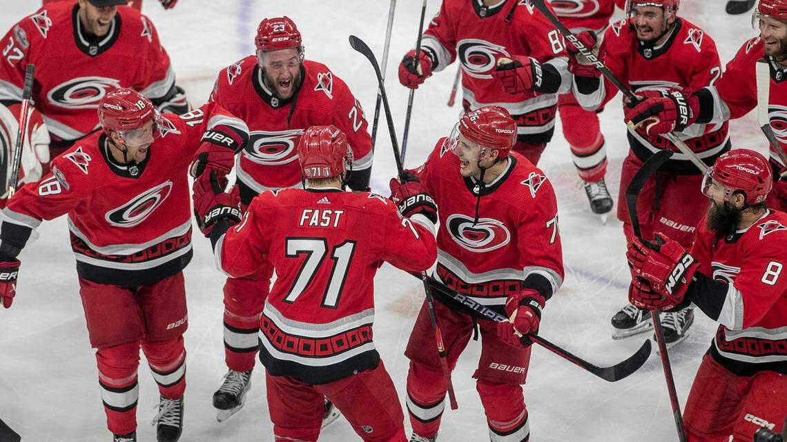 The Carolina Hurricanes swarm to Jesper Fast (71) during their post-game celebration after Fast scored the game winning goal in overtime to secure a 3-2 victory over the New Jersey Devils, clinching their second round Stanley Cup series on Thursday, May 11, 2023 at PNC Arena in Raleigh, N.C.