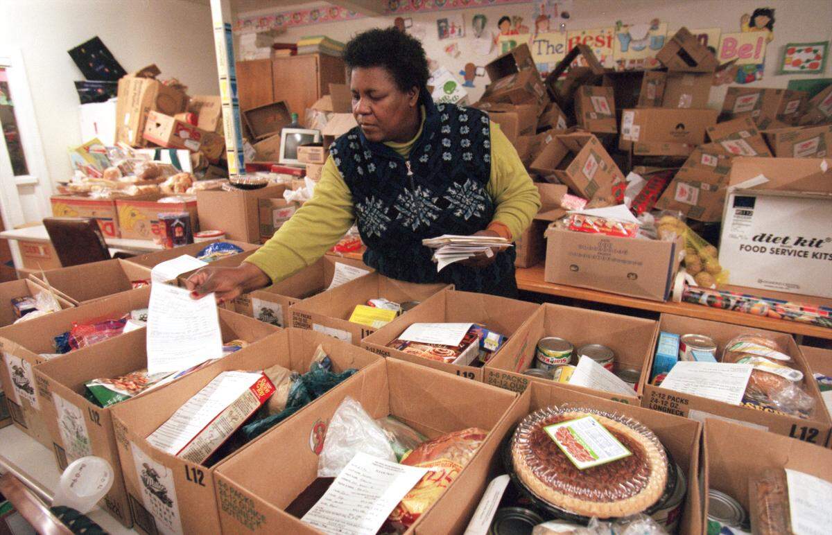 Sylvia Wiggins places information sheets listing the names of needy families on boxes of food that will be delivered in time for Christmas throughout the area in December 2000. Wiggins, the director of the Helping Hand Mission is leading the effort to collect food and presents for almost 500 families.