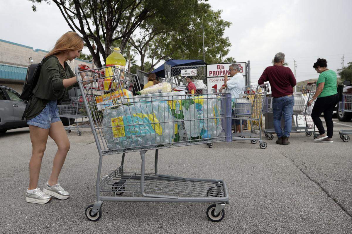 A shopper walks to her vehicle with a cart full of bottled water at BJ’s Wholesale Club in preparation for Hurricane Dorian, Thursday, Aug. 29, 2019, in Hialeah, Fla. Hurricane Dorian is heading towards Florida for a possible direct hit on the state over Labor Day. (AP Photo/Lynne Sladky)