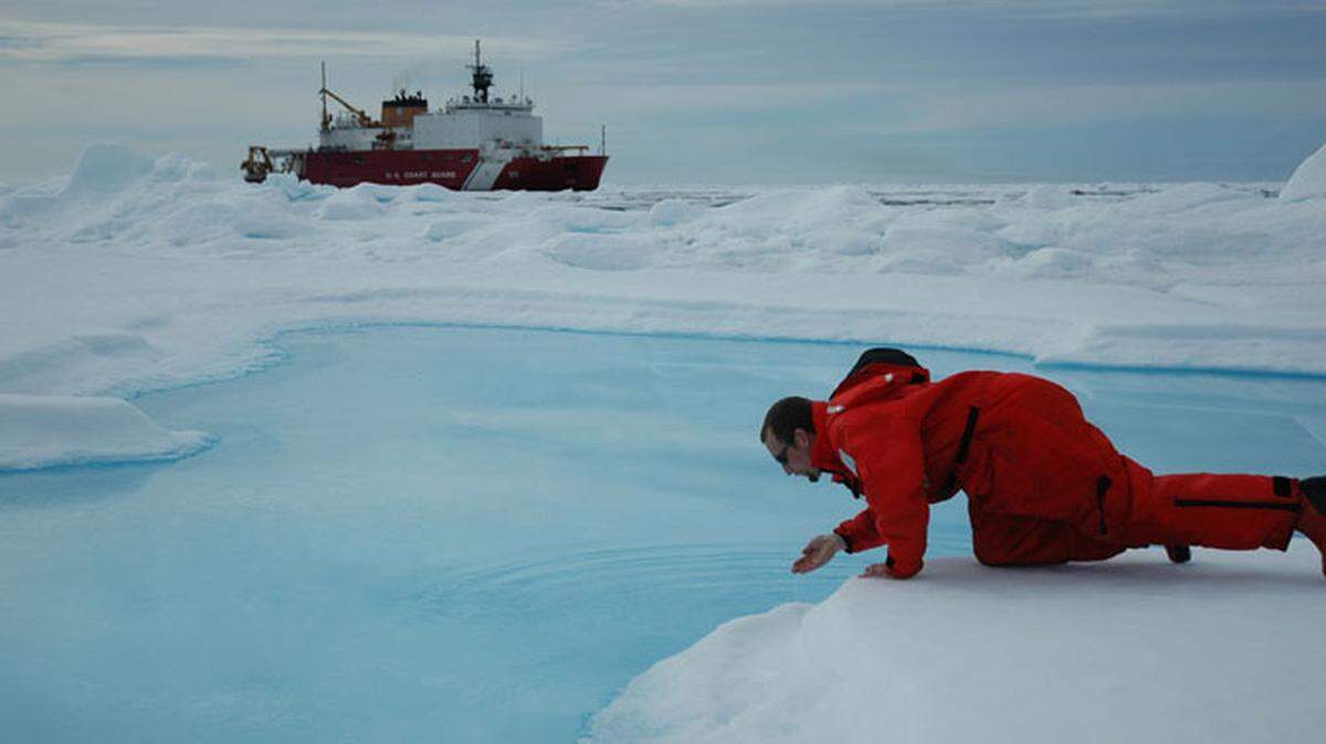 Scientist testing the waters, with the U.S. Coast Guard Icebreaker Heay in the background. Arctic Ocean, Canada Basin. (Photo credit: Jeremy Potter NOAA/OAR/OER)