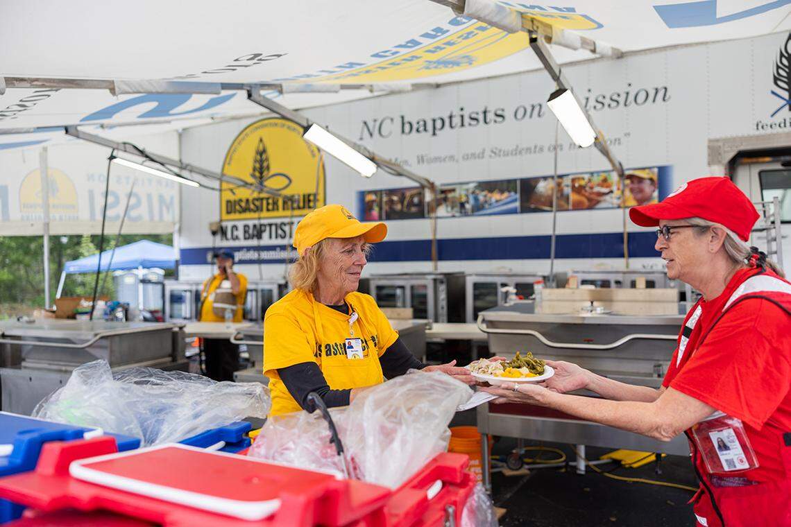 Barbara Garland, left, with NC Baptists on Mission Disaster Relief hands out food to other volunteers at Biltmore Church Arden Campus in Arden, N.C. on Monday, September 30, 2024.