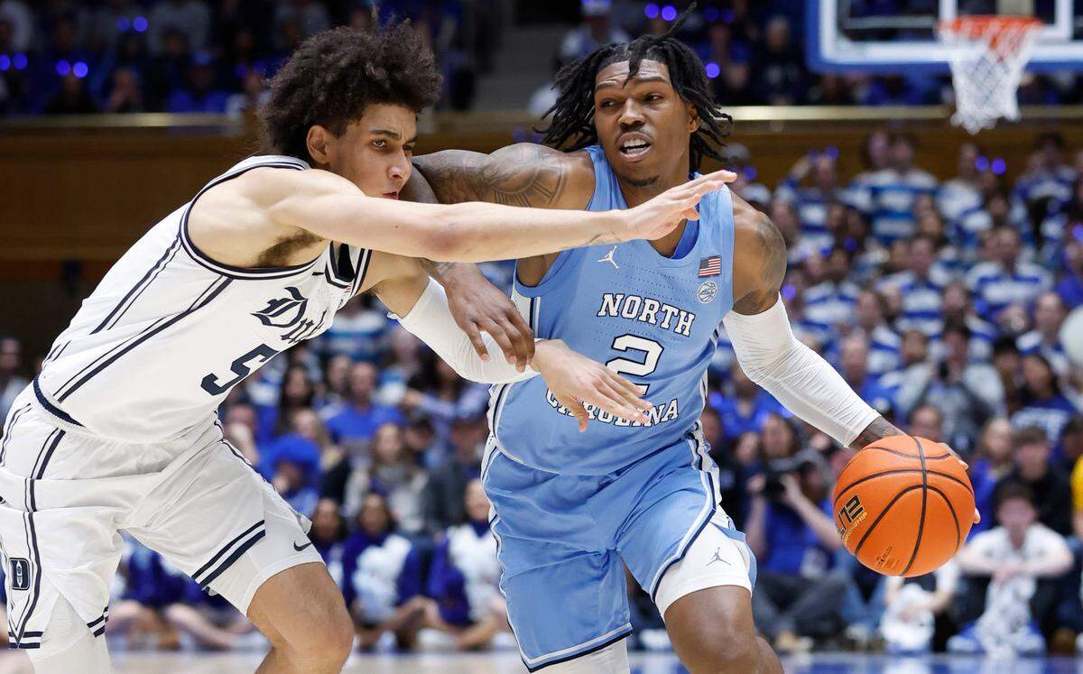 North Carolina’s Caleb Love (2) drives around Duke’s Tyrese Proctor (5) during the first half of Duke’s game against UNC at Cameron Indoor Stadium in Durham, N.C., Saturday, Feb. 4, 2023.