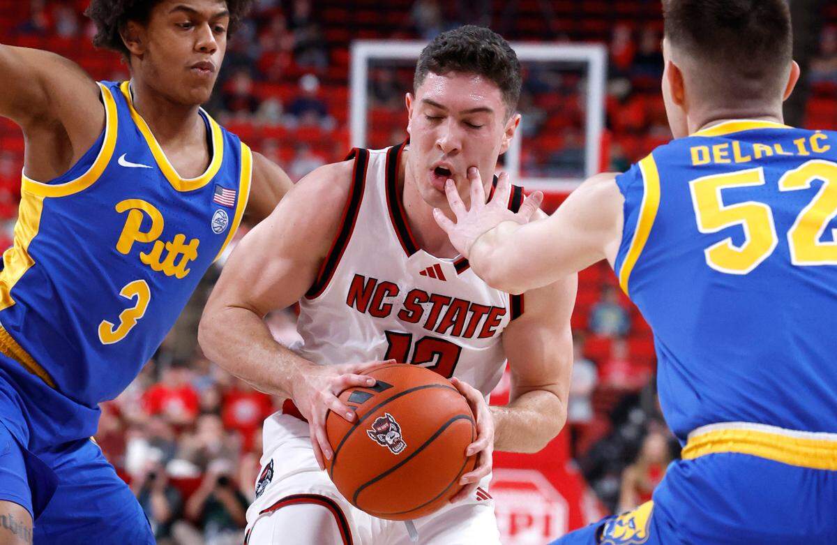 N.C. State’s Michael O’Connell (12) is fouled by Pittsburgh’s Amsal Delalic (52) as Brandin Cummings (3) also defends during the first half of N.C. State’s game against Pitt at the Lenovo Center in Raleigh, N.C., Wednesday, March 5, 2025.