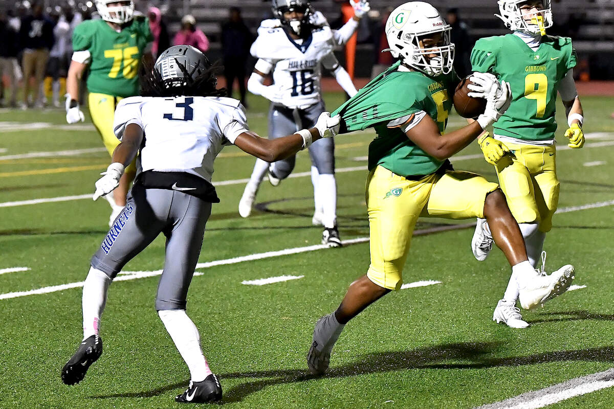 Cardinal Gibbons running back Kendall Scotton (5) runs for the touchdown against the uniform snag by Hillside’s Erick Bonner (3) during the first half. The Cardinal Gibbons Crusaders and the Durham Hillside Hornets met in the third round of the NCHSAA 4A playoffs in Raleigh, N.C. on November 29, 2024.