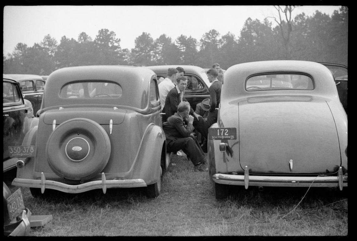 Fans who could not get tickets to the sold-out Duke-Carolina game in Durham, NC gather around a radio in the parking lot.