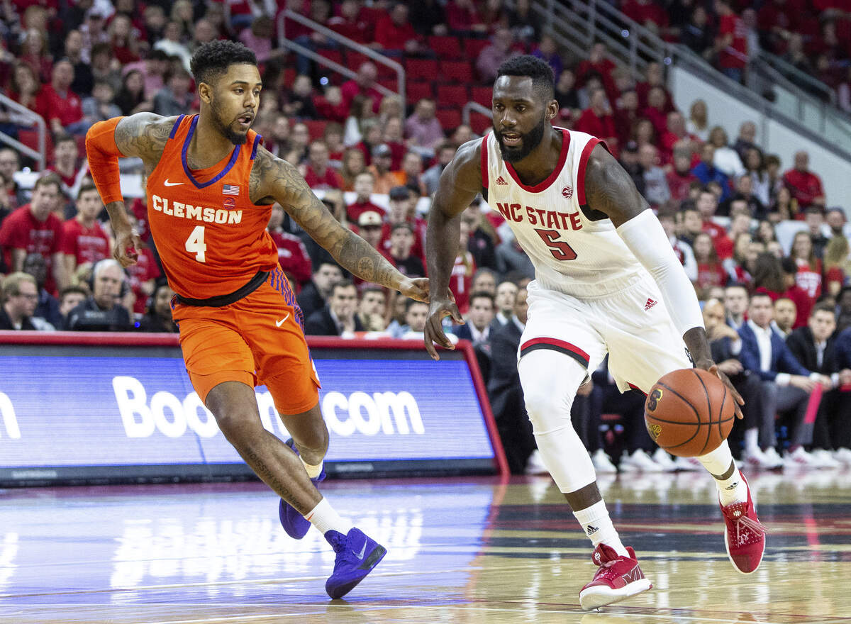 North Carolina State’s Eric Lockett (5) drives against Clemson’s Shelton Mitchell (4) during the first half of an NCAA college basketball game in Raleigh, N.C., Saturday, Jan. 26, 2019. (AP Photo/Ben McKeown)