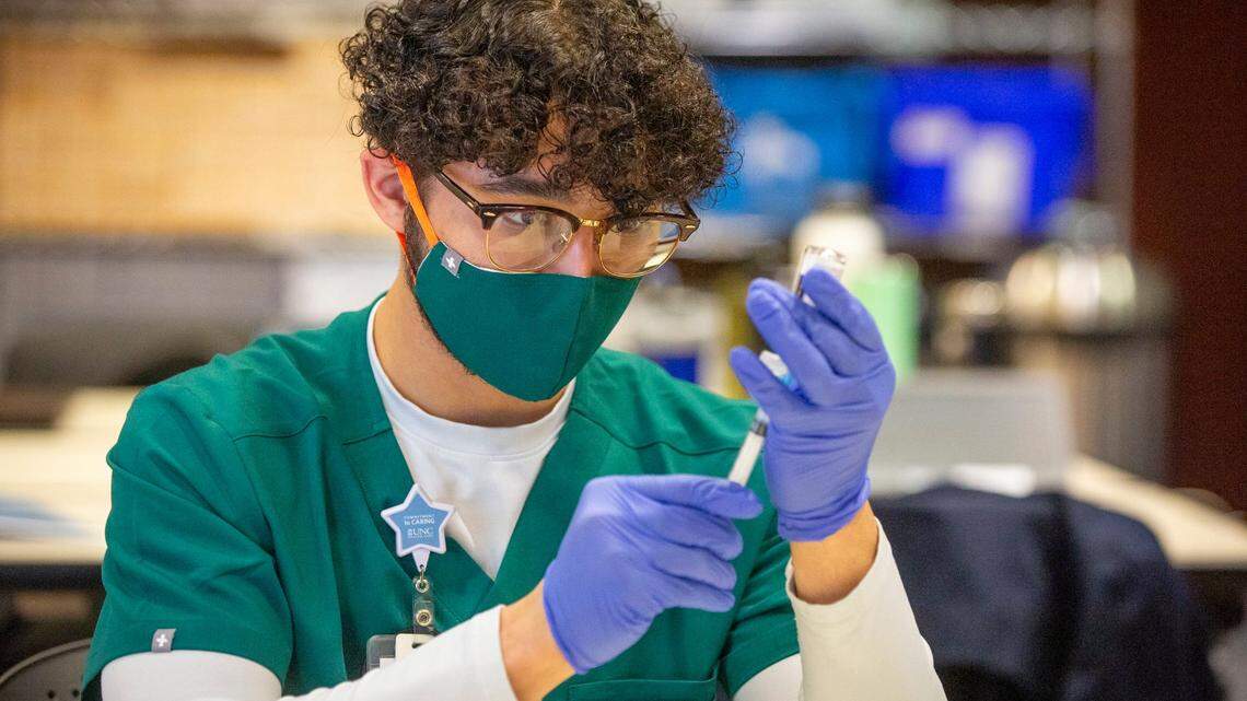 Frederick Donnelly, a pharmacy technician, fills syringes with the Moderna COVID-19 vaccine to be administered by UNC Healthcare to patients in Group 1 of Phase 1b, now open to patients age 65 and older, at the Friday Center, on Jan. 14 in Chapel Hill.