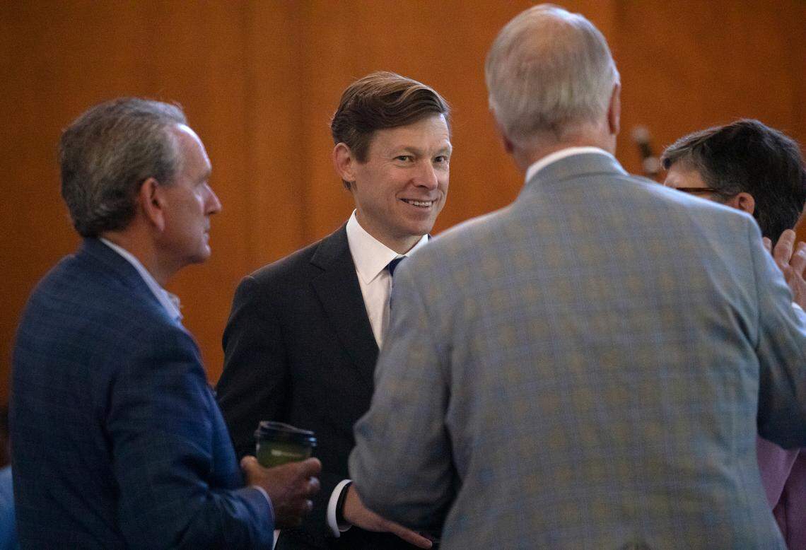 UNC-Chapel Hill Chancellor Lee Roberts, center, speaks with Athletics Director Bubba Cunningham, left, and other guests during an event honoring university employees on Wednesday, Oct. 9, 2024, in Chapel Hill, N.C.