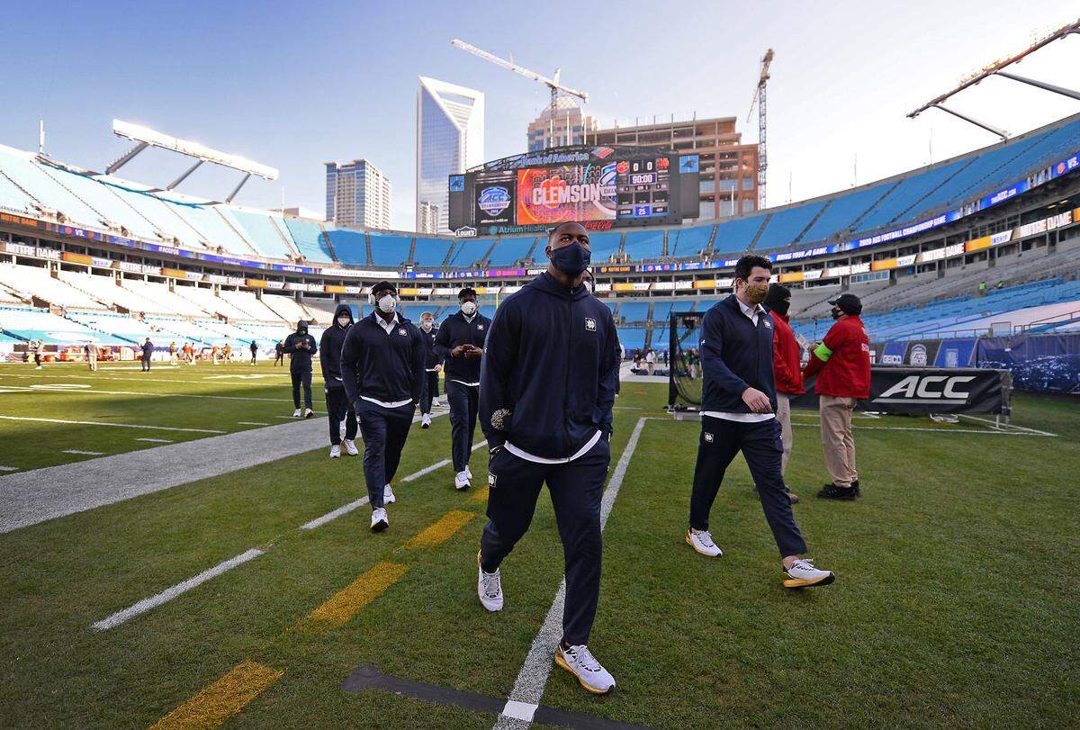 Members of the Notre Dame Fighting Irish football team walk across the field at Charlotte’s Bank of America Stadium in 2020, before facing Clemson in that year’s ACC title game.
