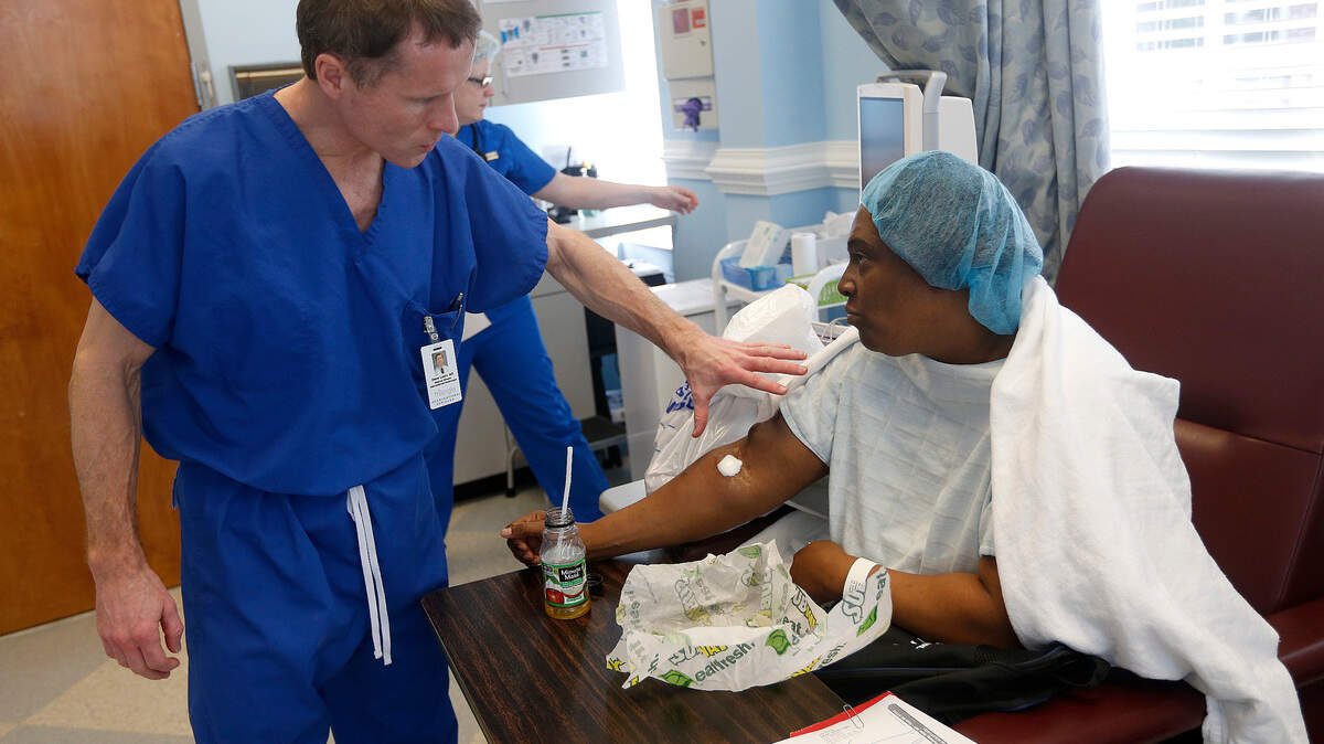 Dr. Steve Loehr checks on Angela Johnson in the recovery room at Triangle Vascular Associates in Cary in 2015. Blue Cross says deeper partnerships with providers will hold down health care costs.