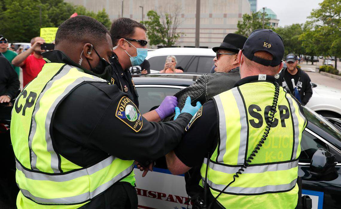 Police make an arrest during the ReOpenNC protest in downtown Raleigh, N.C., Tuesday, May 5, 2020.