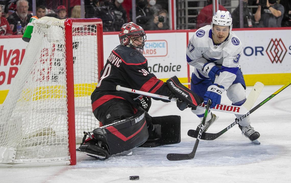 Tampa Bay’s Yanni Gourde (37) works the puck in close against Carolina Hurricanes’ goalie Alex Nedeljkovic (39) during the first period in game five of their Stanley Cup series on Tuesday, June 8, 2021 at PNC Arena in Raleigh, N.C.