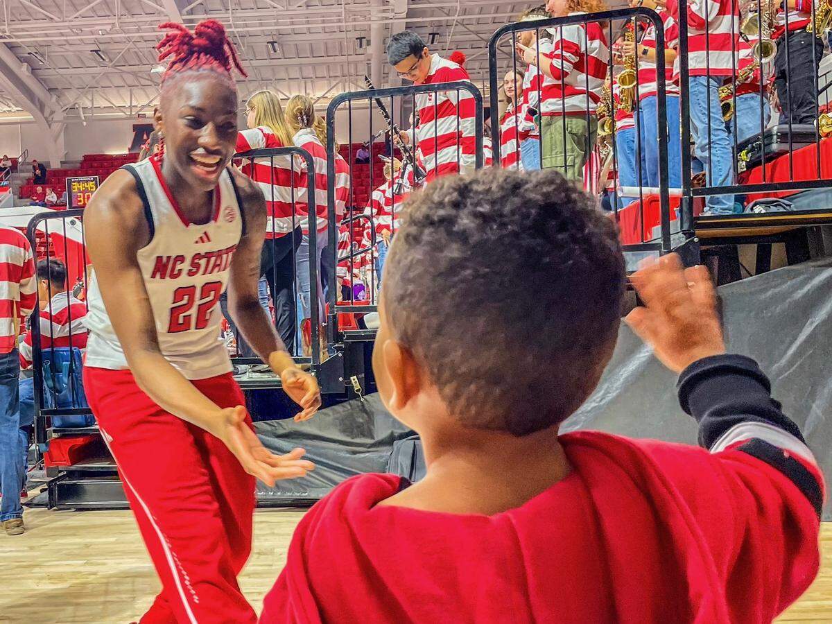 Former N.C. State guard Saniya Rivers greets fan Braylon Collins after a game at Reynolds Coliseum in Raleigh, NC.