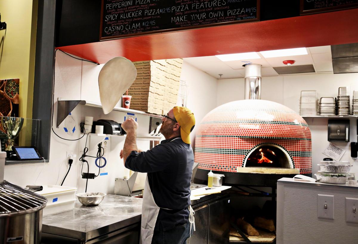 Bella’s Wood-Fired Pizza’s general manager Drew Carelle throws a pie at Morgan Street Food Hall in downtown Raleigh on Tuesday, March, 5, 2019.