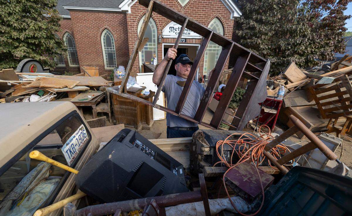 Randall Sigmon of Old Fort, moves salvaged items from the flooded sanctuary of Old Fort United Methodist Church on Saturday, October 5, 2024 in Old Fort, N.C. More than four feet of water from Mill Creek flooded the building during Hurricane Helene.