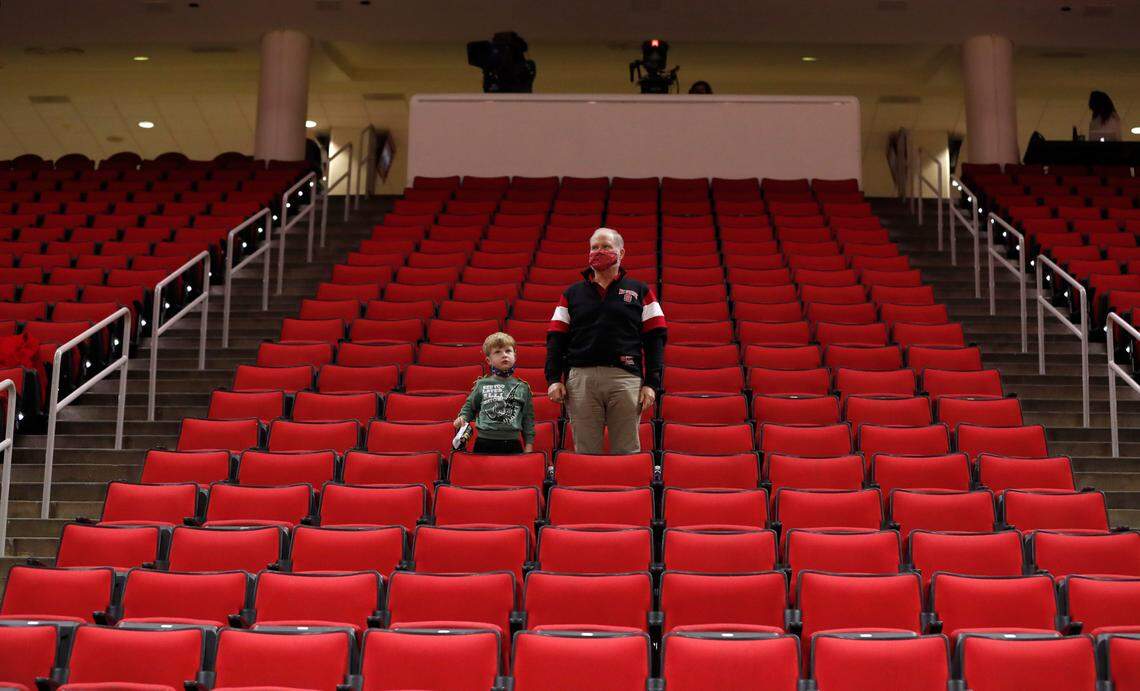 Fans stand for the national anthem before N.C. State’s game against Campbell at PNC Arena in Raleigh, N.C., Saturday, Dec. 19, 2020.