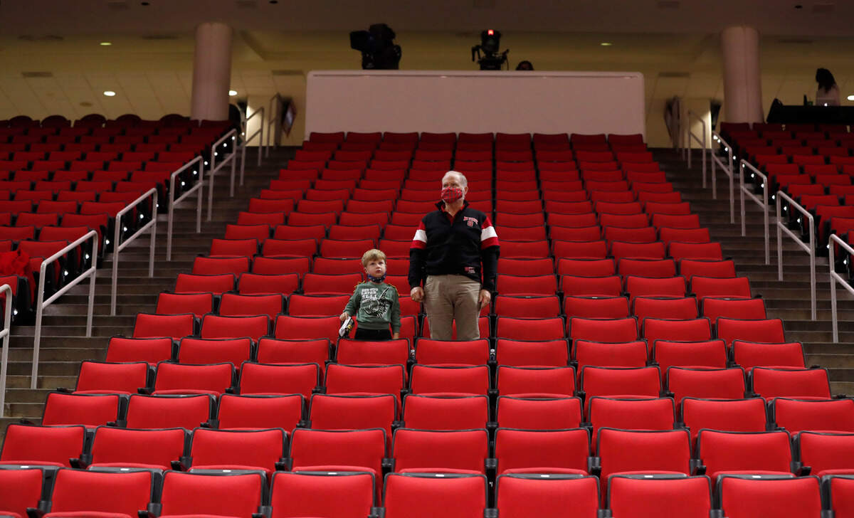 Fans stand for the national anthem before N.C. State’s game against Campbell at PNC Arena in Raleigh, N.C., Saturday, Dec. 19, 2020.