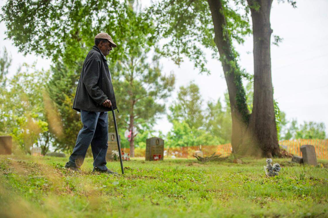 Former caretaker Rudolph Loftin Sr., now 97, walks with his cane through the Oak Grove Cemetery, which was founded by freed African-Americans after the Civil War and now has lost more of its tree buffer to widening of the I-440 Beltline, that separated it from the rest of the Method community in the 1960s, on Tuesday, May 11, 2021, in Raleigh, N.C.