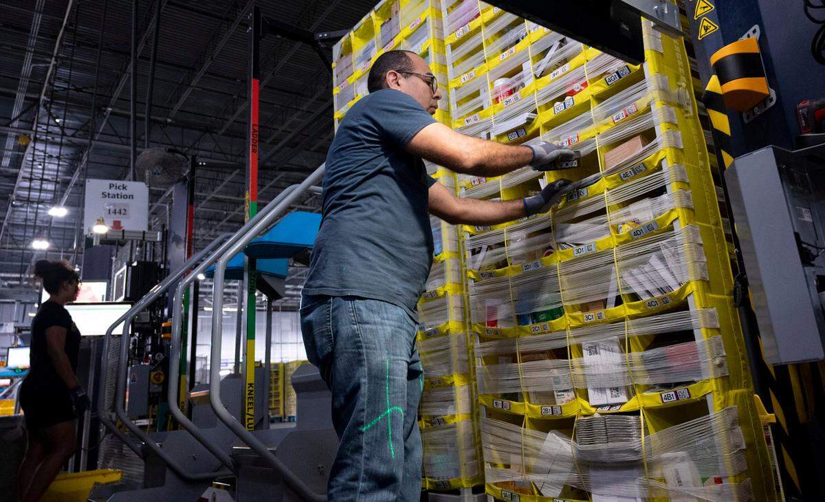 Amazon worker sort through items at the Pick Station in the Same-Day Delivery Fulfillment Center in Durham on Wednesday, July 10, 2024. The items are brought to them on robot pods that operate 24 hours a day.