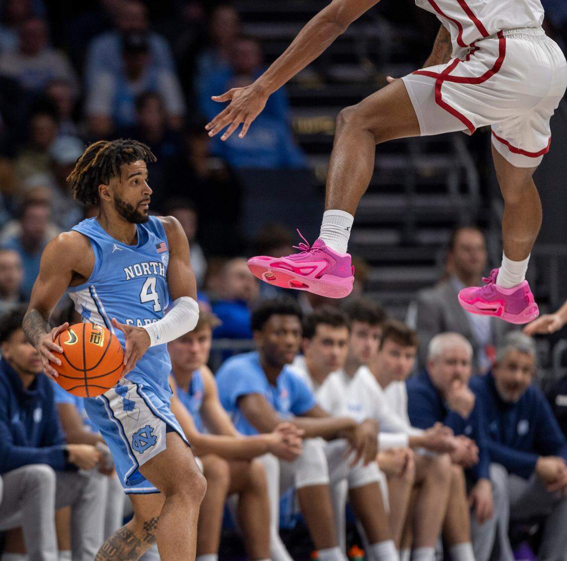 North Carolina’s R.J. Davis (4) looks for an open teammate as Oklahoma’s Jalon Moore (14) defends in the second half on Wednesday, December 20, 2023 at the Spectrum Center in Charlotte, N.C.