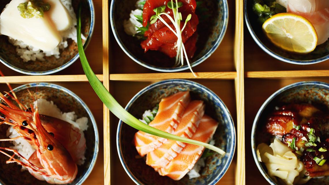 
Presentations are exceptionally attractive at Aroma Korea, even by sushi bar standards. Chirashi don, traditionally served as an assortment of sashimi casually strewn over sushi rice (chirashi means "scattered"), is here presented as six separate stoneware bowls in a bento box, each containing a different fish on its own small mound of rice, each with a different garnish.
