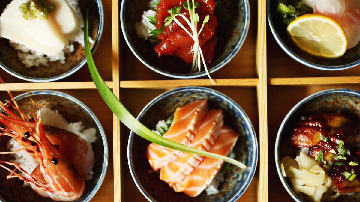 
Presentations are exceptionally attractive at Aroma Korea, even by sushi bar standards. Chirashi don, traditionally served as an assortment of sashimi casually strewn over sushi rice (chirashi means "scattered"), is here presented as six separate stoneware bowls in a bento box, each containing a different fish on its own small mound of rice, each with a different garnish.
