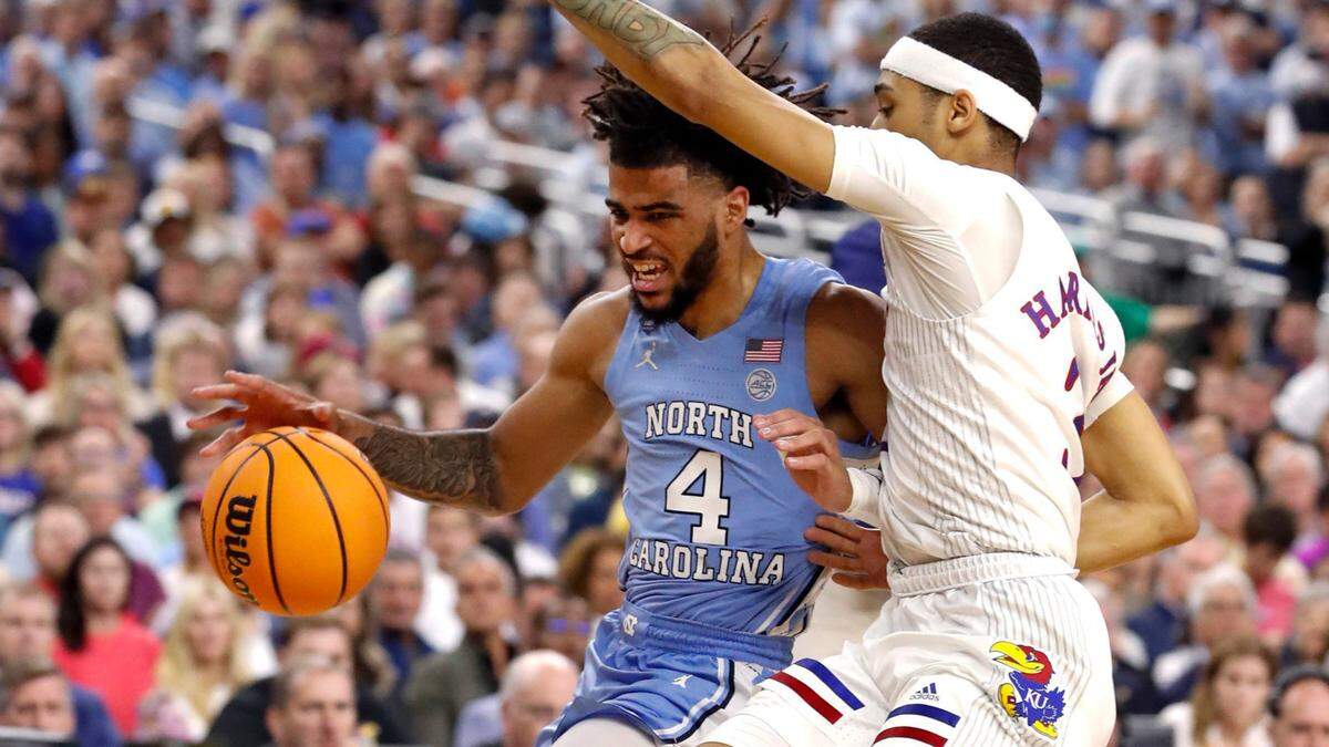 North Carolina’s R.J. Davis (4) drives by Kansas’ Dajuan Harris Jr. (3) during the first half of UNCís game against Kansas in the NCAA Menís National Championship at the Caesars Superdome in New Orleans, La., Monday, April 4, 2022.