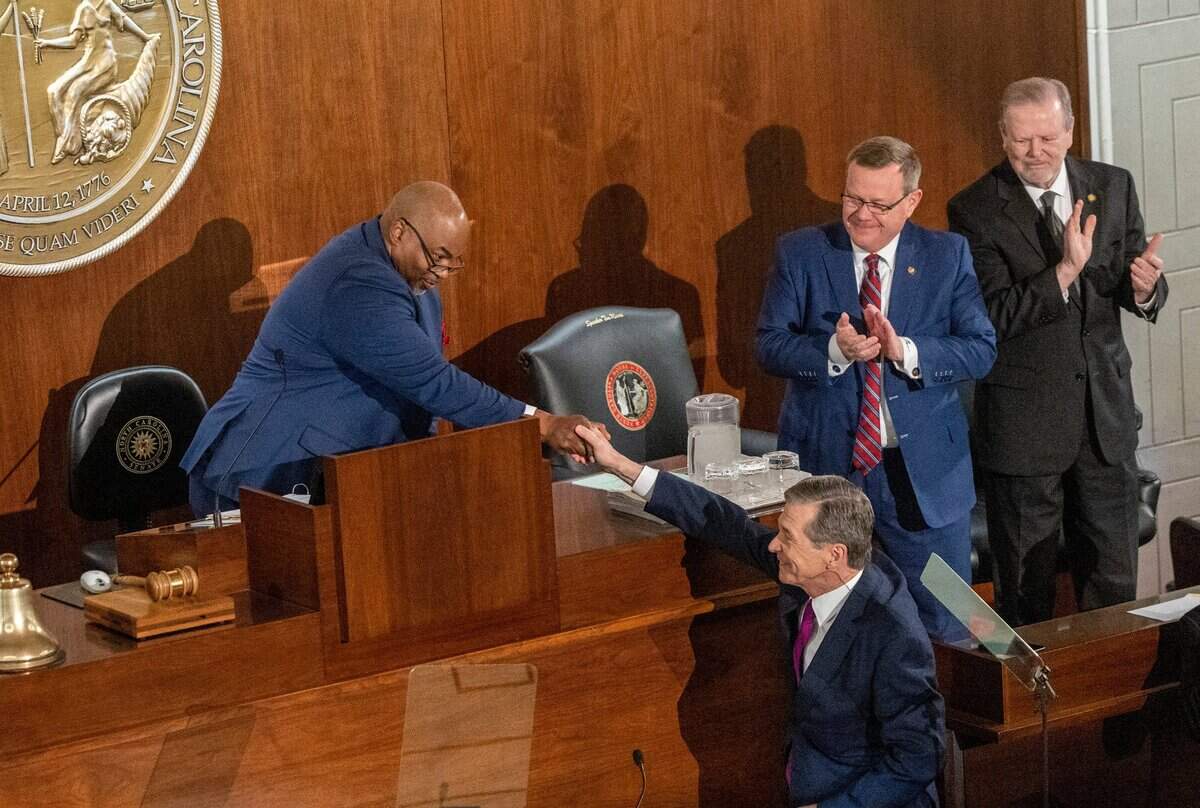 Gov. Roy Cooper shakes hands with Lt. Gov. Mark Robinson as House Speaker Tim Moore and Senate Leader Phil Berger look on before Cooper delivered his State of the State address to a joint session of the N.C. General Assembly on Monday, March 6, 2023.
