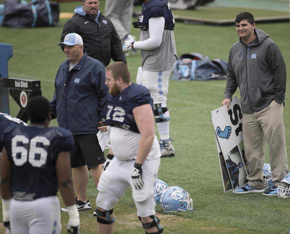 Tommy Hatton watches his teammates as offensive line coach Chris Kapilovic works with the team during practice in March 2018 in Chapel Hill.