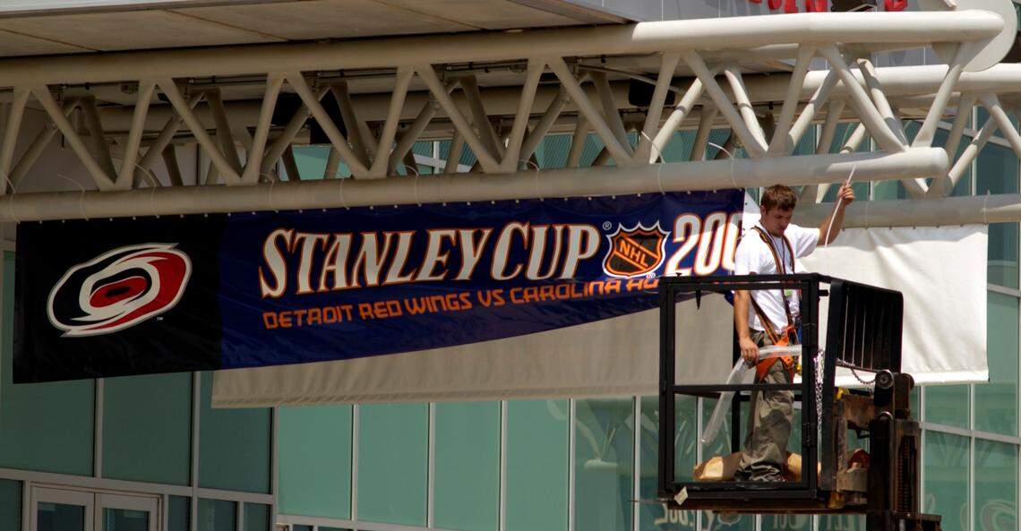 John Sandor, Operations Supervisor for the Carolina Hurricanes’ Changeover Crew, puts up banners in 2002 at the Entertainment and Sports Arena heralding the coming contest with the Detroit Red Wings for the Stanley Cup.