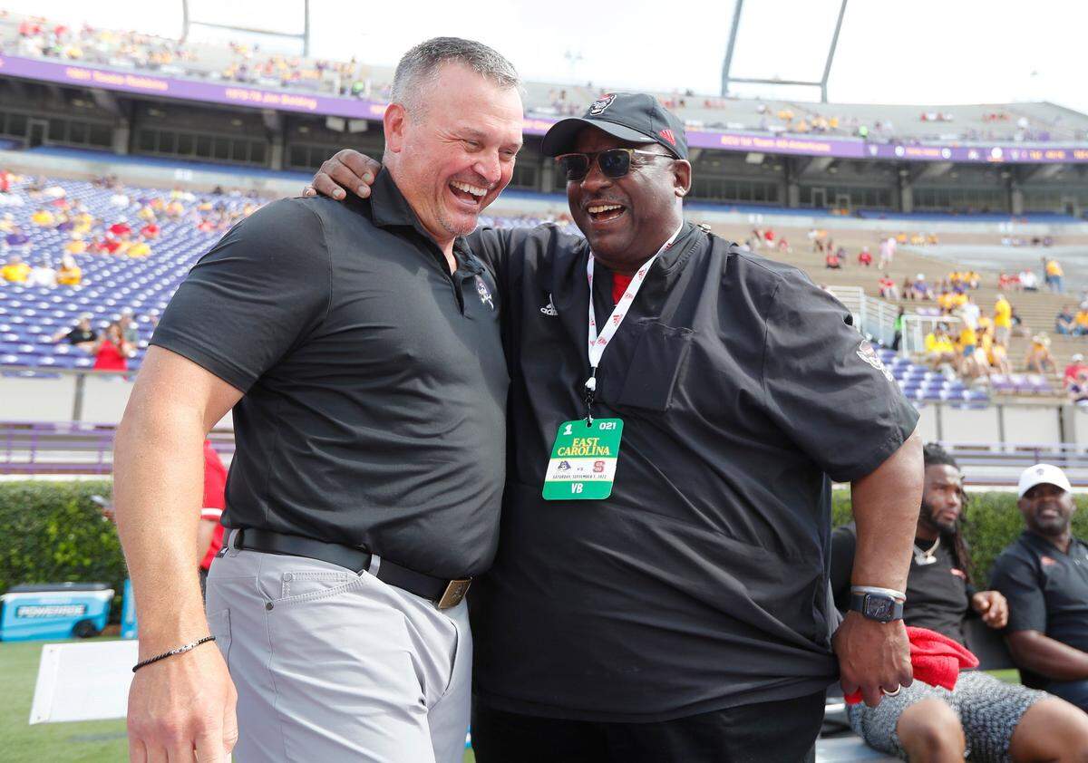 East Carolina head coach Mike Houston laughs with N.C. State special assistant to the head coach Ruffin McNeill before N.C. States game against ECU at Dowdy-Ficklen Stadium in Greenville, N.C., Saturday, Sept. 3, 2022.