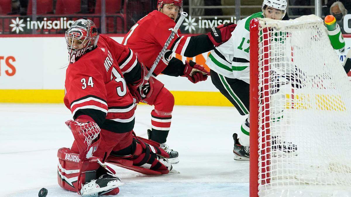 Carolina Hurricanes goaltender Petr Mrazek (34) defends the goal while Hurricanes right wing Jesper Fast defends against Dallas Stars right wing Nick Caamano (17) during the first period of an NHL hockey game in Raleigh, N.C., Sunday, April 4, 2021. (AP Photo/Gerry Broome)