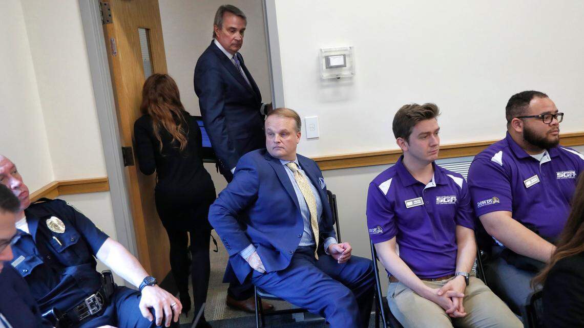 Phil Lewis, center, standing, acknowledges ECU Board of Trustees member Robert Moore as he leaves after Lewis resigned from the board during a UNC System Board of Governors special meeting Friday, Feb. 7, 2020. The board met to discuss allegations that two ECU trustees improperly tried to influence student government elections by offering financial support to a potential candidate.
