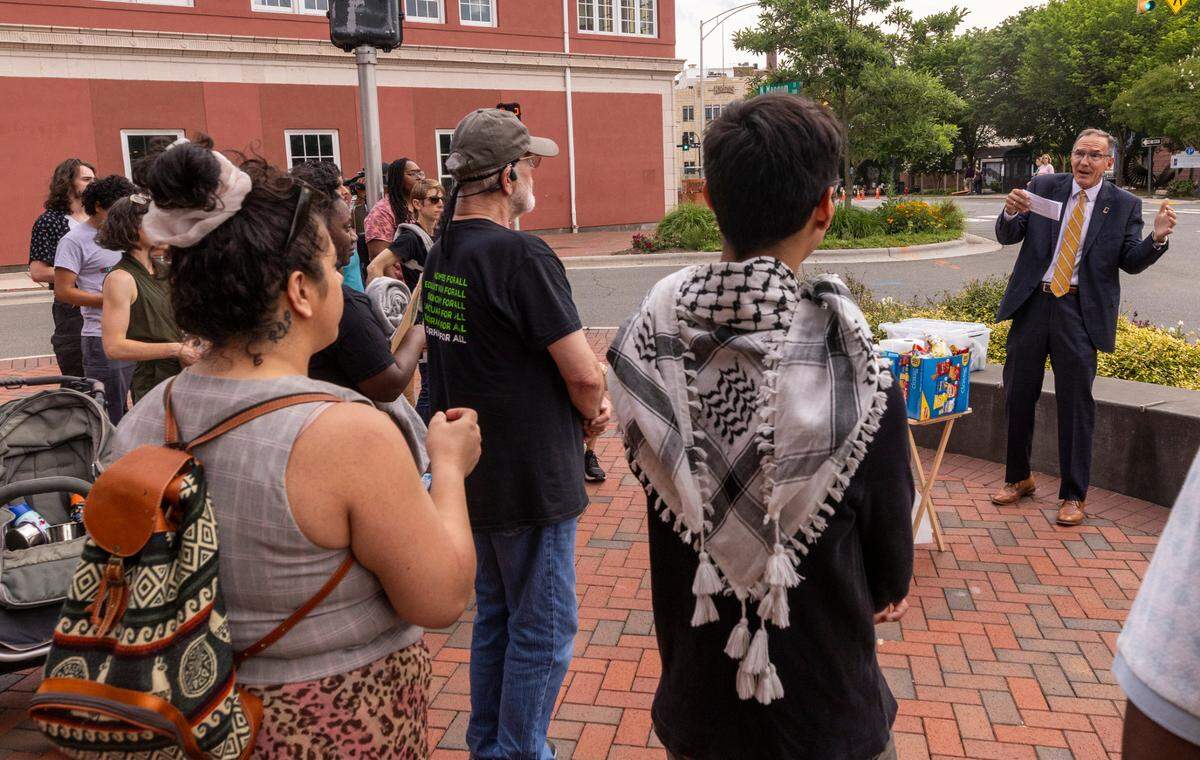 Durham City Council Member Carl Rise, right, speaks with demonstrators who were advocating for a higher minimum wage for city workers prior to a budget hearing at City Hall on Monday, June 3, 2024.