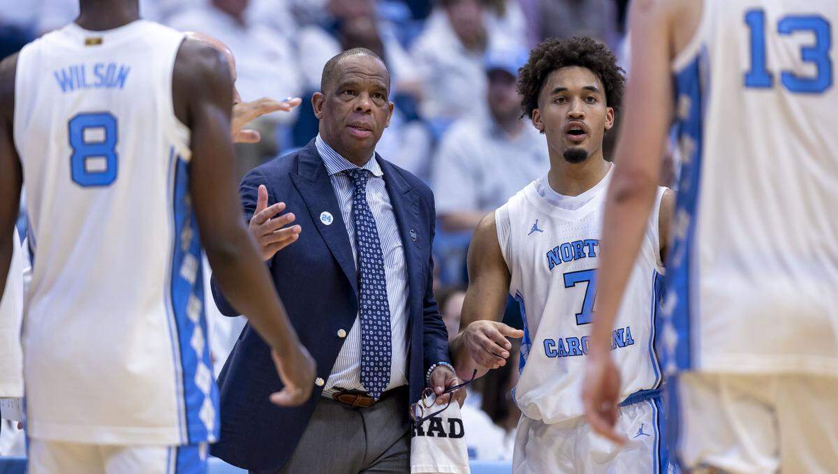 North Carolina coach Hubert Davis and guard Seth Trimble (7) call in the team for a huddle during a time-out in the second half against Kansas on Friday, November 7, 2025 at the Smith Center in Chapel Hill, N.C.