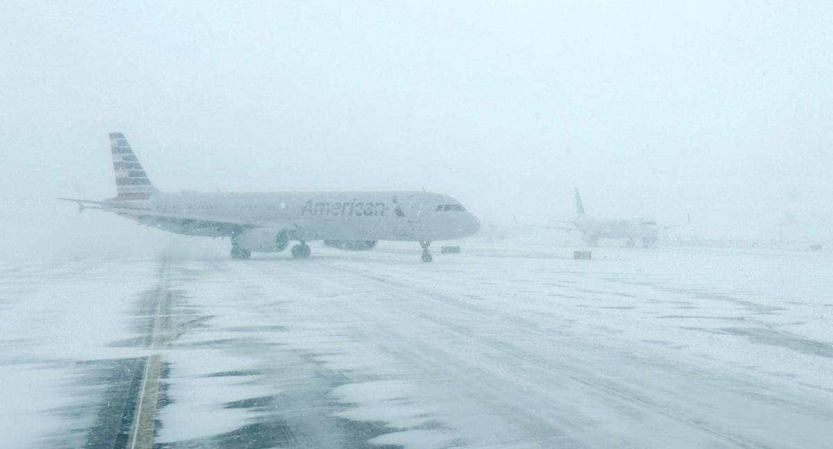 An American Airlines plane moves across a snow-covered tarmac at Charlotte Douglas International Airport on Saturday, Jan. 31, 2026. The  airport experienced hundreds of flight delays and cancellations this weekend due to the snowstorm.