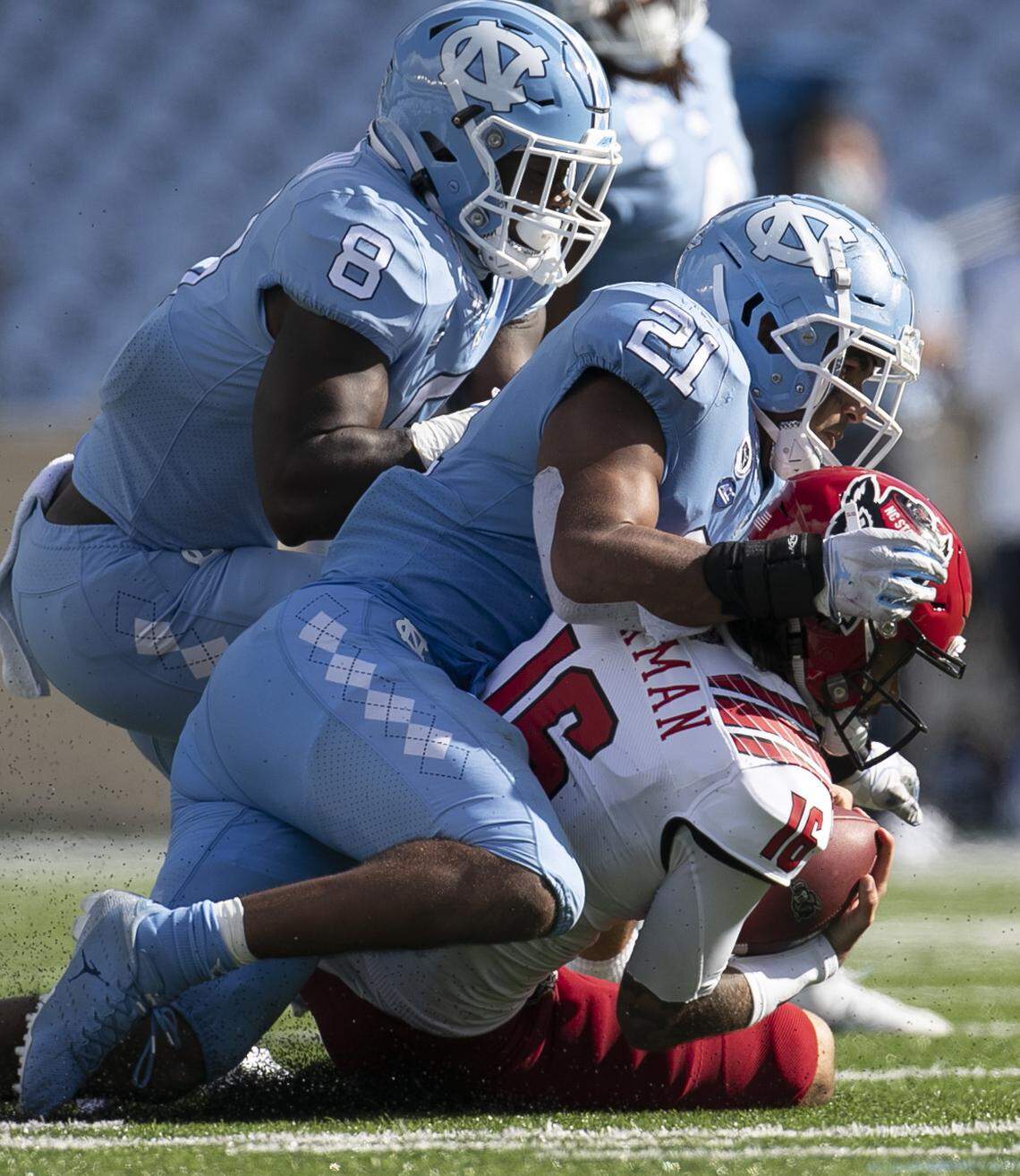 N.C. State quarterback Bailey Hockman (16) is sacked by North Carolina’s Chazz Surratt (21) and Khadry Jackson (8) in 2020.