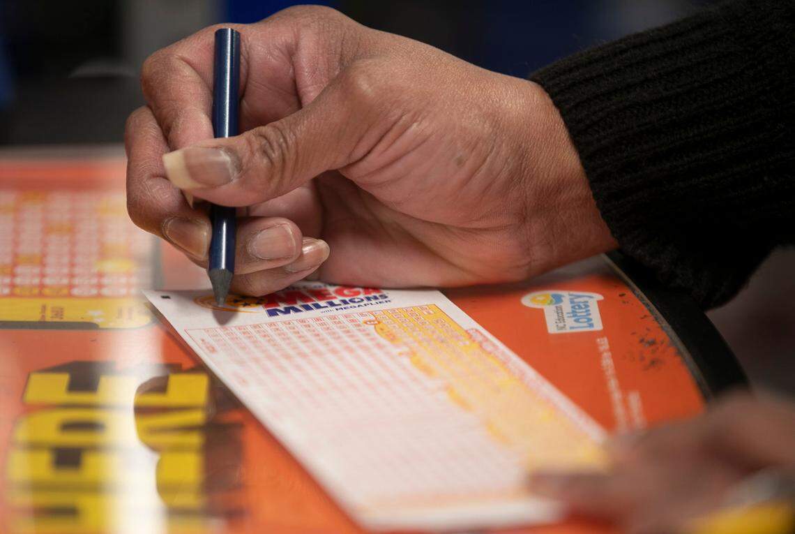 Taniesha Walker plays the Mega Millions lottery at Eagles Express convenience store on Thursday, January 21, 2021 in Knightdale, NC. The jackpot is $970 million and growing with the next drawing on Friday, January 22, 2021.