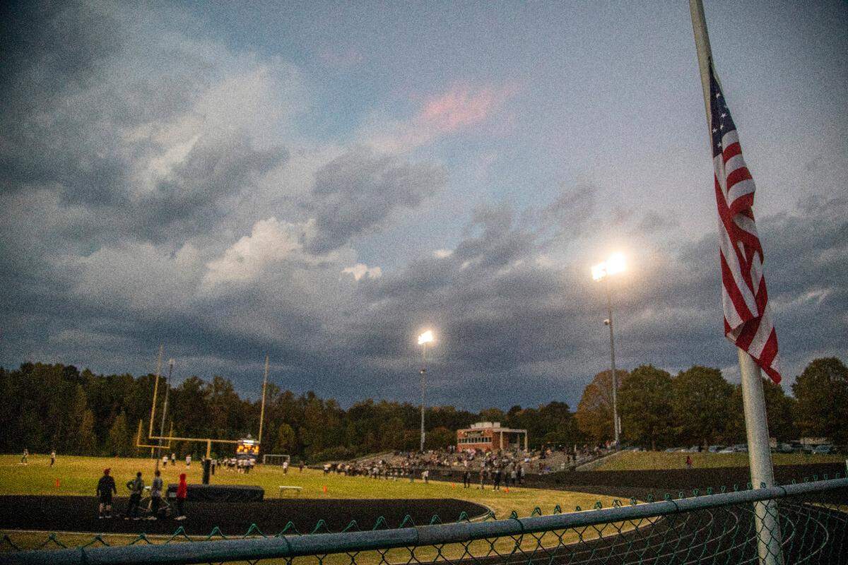 The American Flag flies at half mast during a postponed homecoming football game at Knightdale High School Monday, Oct. 17, 2022 following a mass shooting that left 5 people dead Thursday in Raleigh’s Hedingham neighborhood. James Thompson, 16, a junior at Knightdale High, was one of five people killed in the shooting.