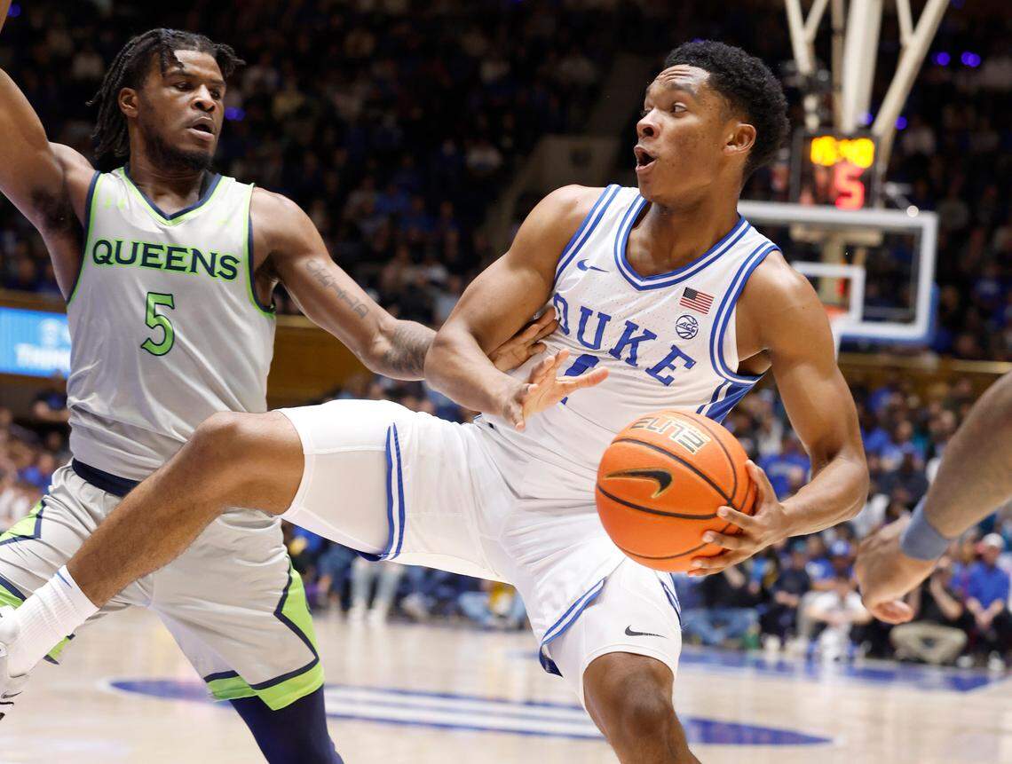 Duke’s Caleb Foster (1) keeps the ball from Queens’ AJ McKee (5) during the first half of Duke’s game against Queens University at Cameron Indoor Stadium in Durham, N.C., Saturday, Dec. 30, 2023.