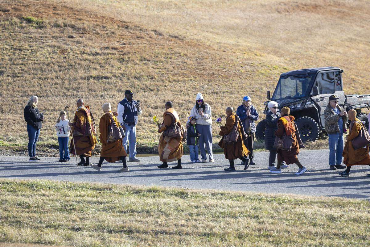 Buddhist Monks pass spectators as they take the ramp to US 421 during the Walk for Peace, as it passes through central North Carolina on Wednesday, January 21, 2026 near Liberty, N.C.