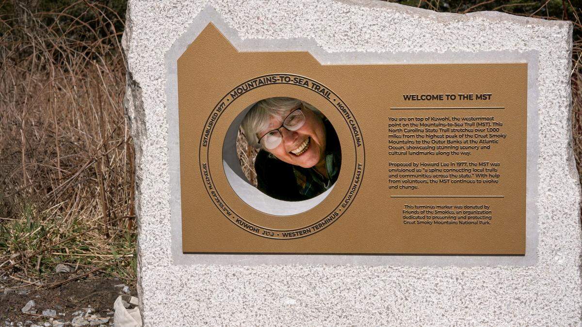 Hiker and outdoors writer Danny Bernstein looks through the monument marking the western end of the Mountains-to-Sea Trail.